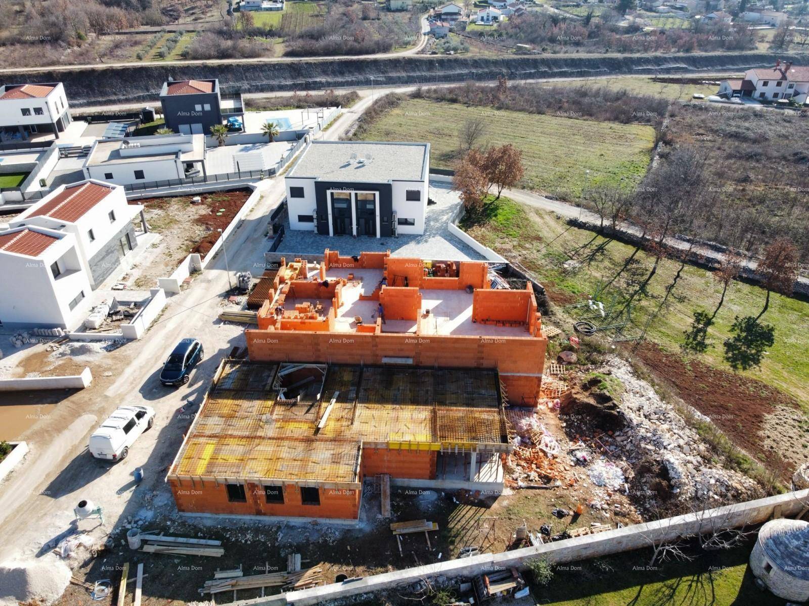 Luftaufnahme einer Baustelle mit mehreren im Bau befindlichen Häusern in einer ländlichen Umgebung.