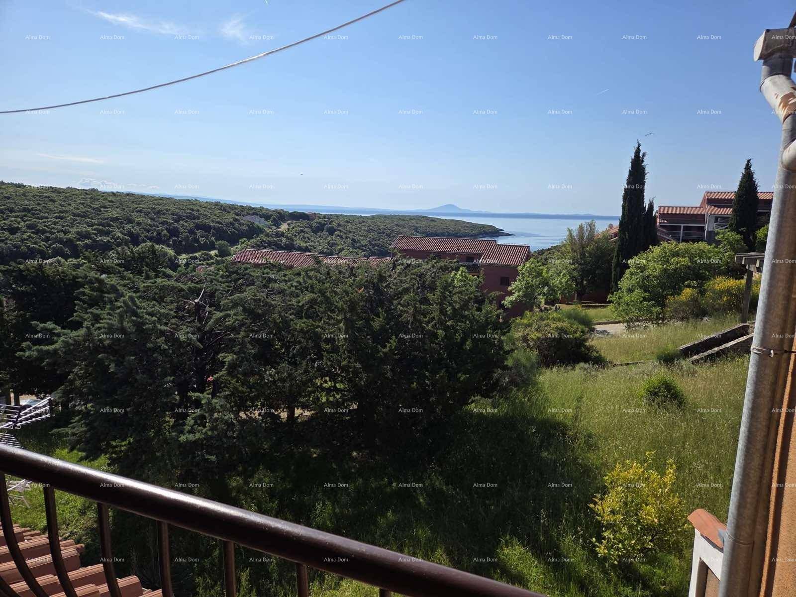 Panoramablick von einem Balkon über die grüne Landschaft und das glitzernde Meer.