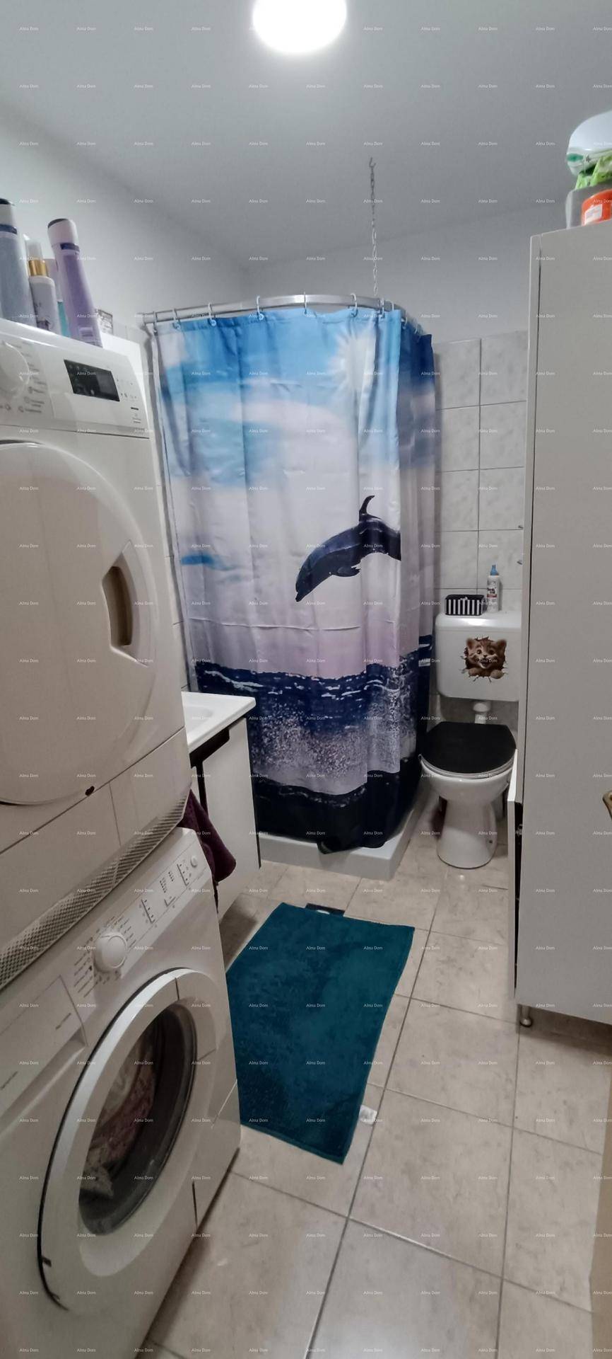 Badezimmer mit Dusche, WC, Waschmaschine und Trockner, praktisch und funktional eingerichtet.