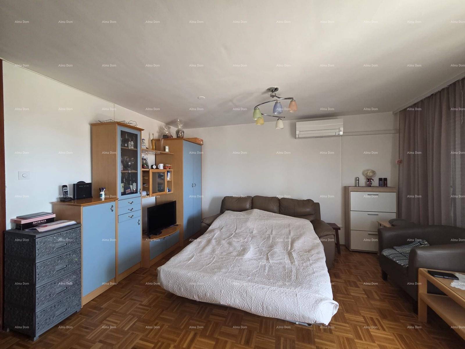 Gemütliches Wohnzimmer mit Parkettboden, Ledersofa und blauen Schränken, ideal zum Entspannen.