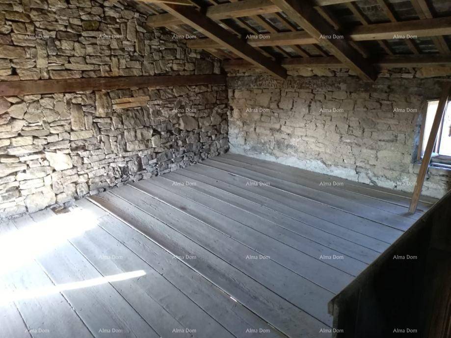 Geräumiger Dachboden mit freiliegenden Holzbalken, Steinwänden und Holzdielenboden, hell beleuchtet.