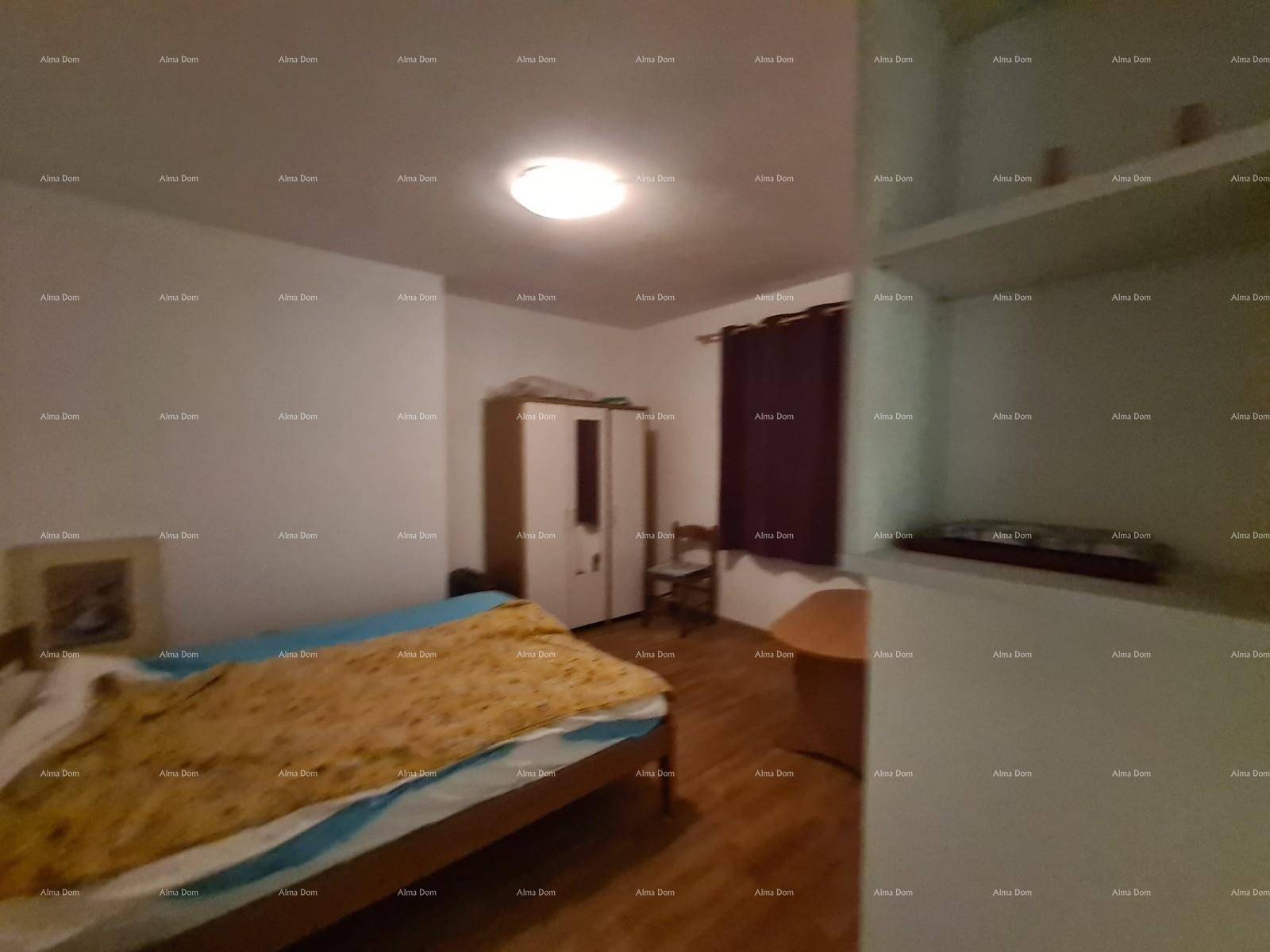 Schlafzimmer mit Doppelbett, Kleiderschrank und Fenster mit Fensterläden.