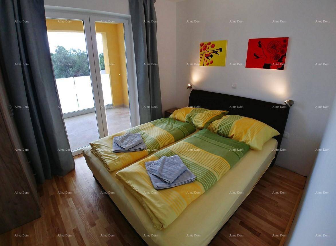 Freundliches Schlafzimmer mit Holzboden, Doppelbett und Zugang zu einem sonnigen Balkon.