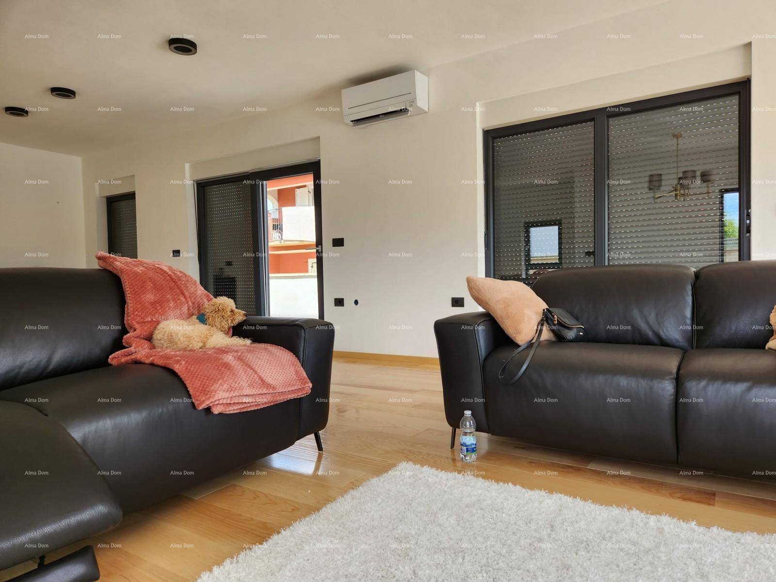Wohnzimmer mit Klimaanlage, bequemen Sofas und großen Fenstern mit Rollläden für Privatsphäre.