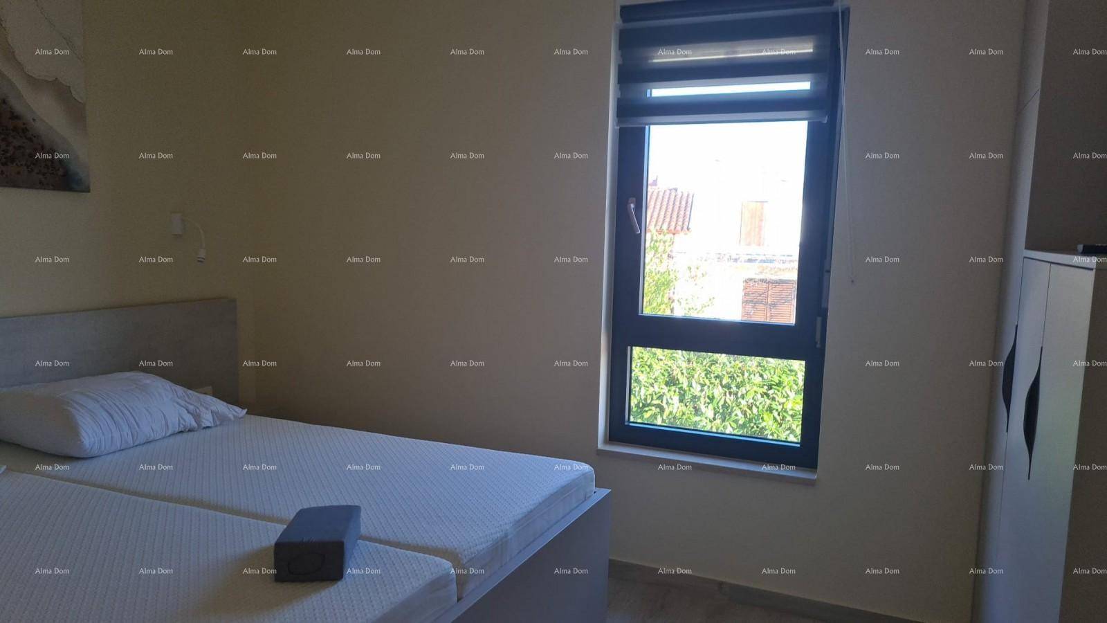 Helles Schlafzimmer mit zwei Einzelbetten und einem großen Fenster mit Blick ins Grüne.