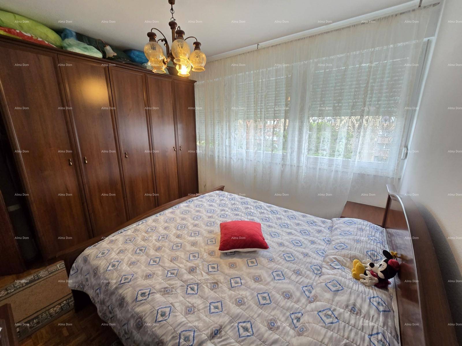 Geräumiges Schlafzimmer mit großem Holzschrank, Doppelbett und hellem Fenster.