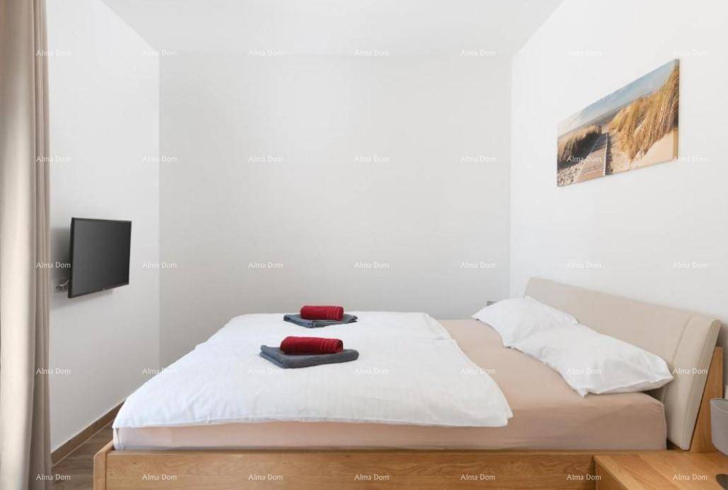 Helles Schlafzimmer mit hellem Holzdoppelbett und an der Wand montiertem Fernseher.