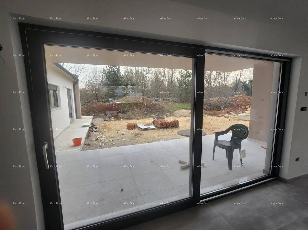 Große Glasschiebetür bietet Zugang zur unfertigen Terrasse und Blick auf den Garten.