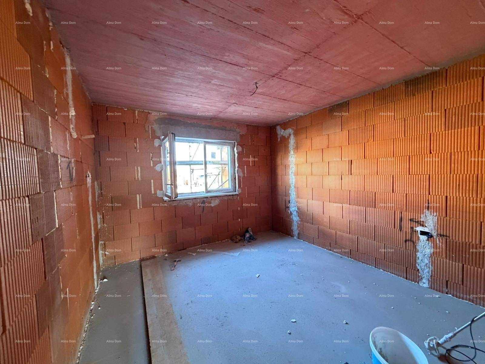 Schlafzimmer im Rohbau mit einem Fenster und unverputzten Ziegelwänden.