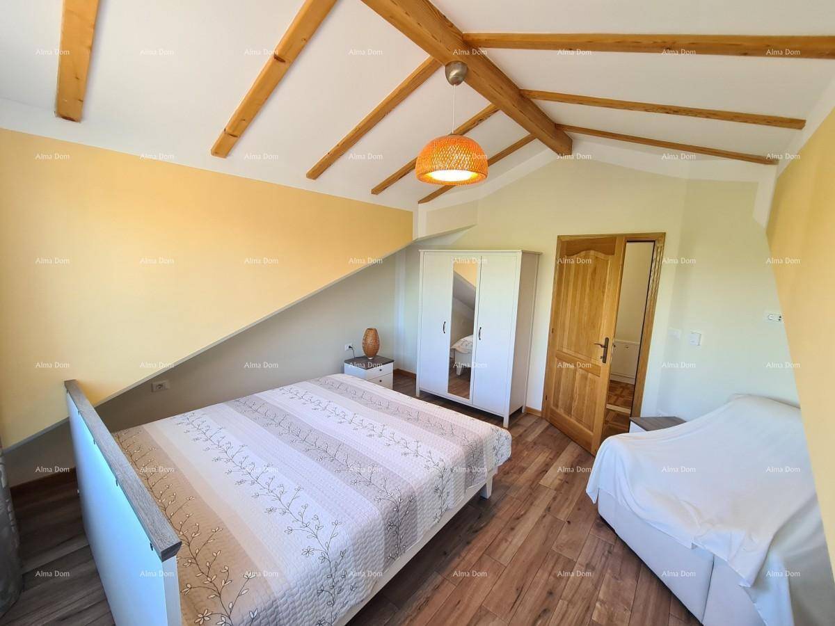 Geräumiges Schlafzimmer mit Holzbalken, Kleiderschrank und zusätzlichem Schlafsofa im Dachgeschoss.