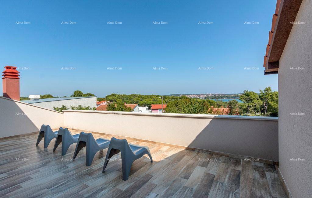 Sonnige Dachterrasse mit Liegestühlen und weitem Blick über die Landschaft und das Meer.