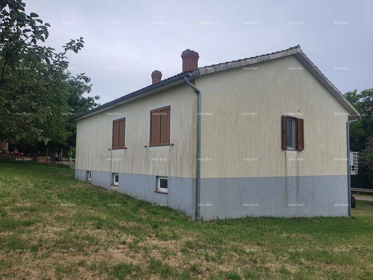 Rückansicht des Hauses mit schlichter Fassade, kleinen Fenstern und zwei Schornsteinen.