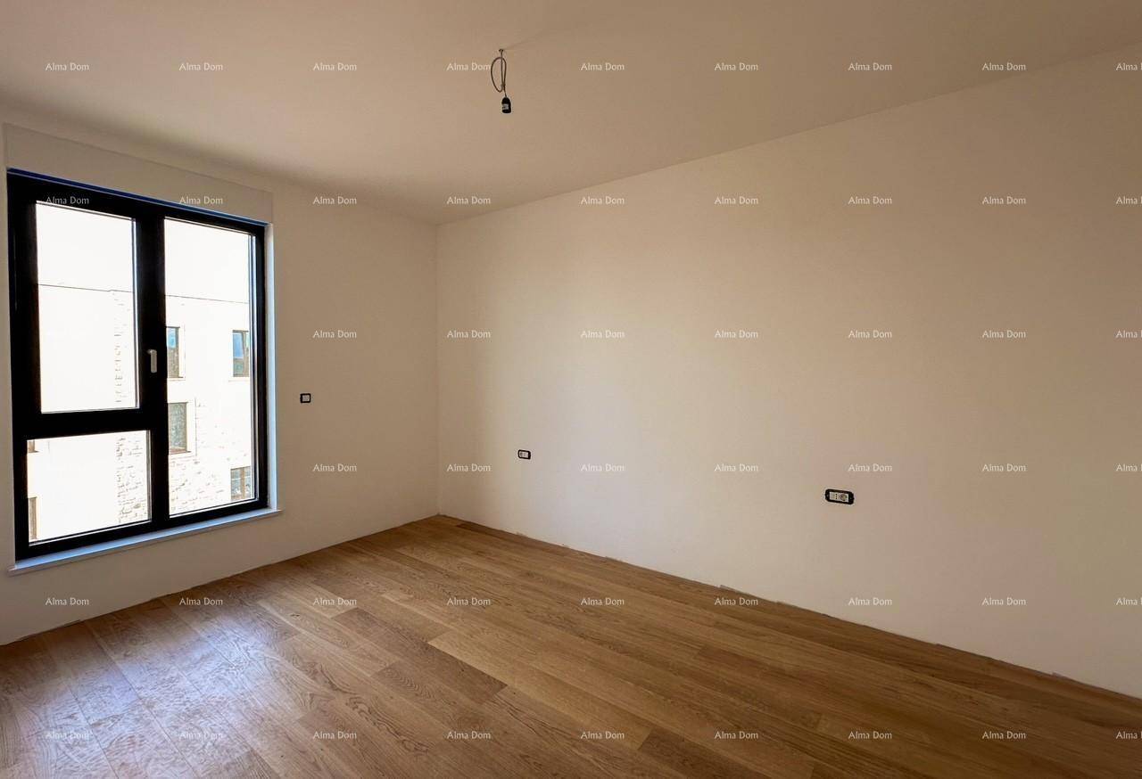 Helles Schlafzimmer im Rohbau mit Holzboden und einem Fenster.