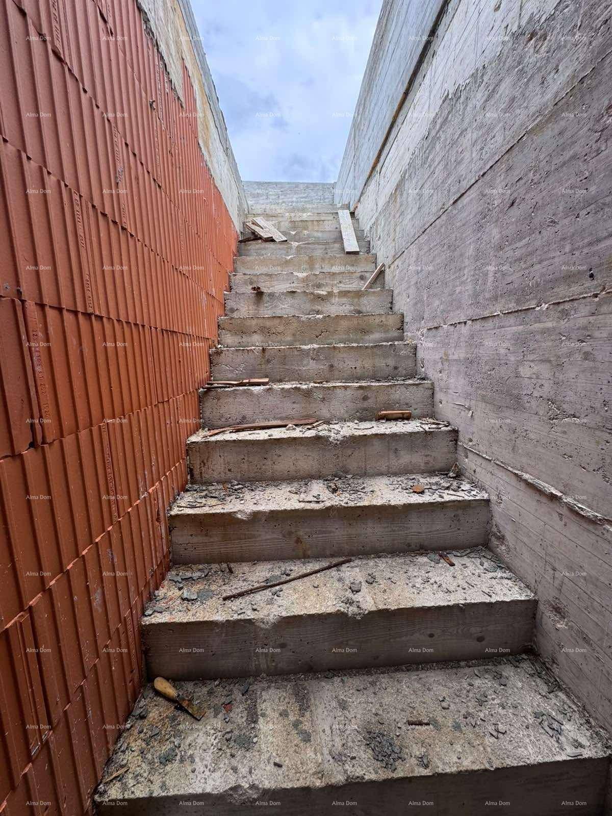 Betontreppe im Rohbau, die zu einem unteren Bereich des Gebäudes führt.