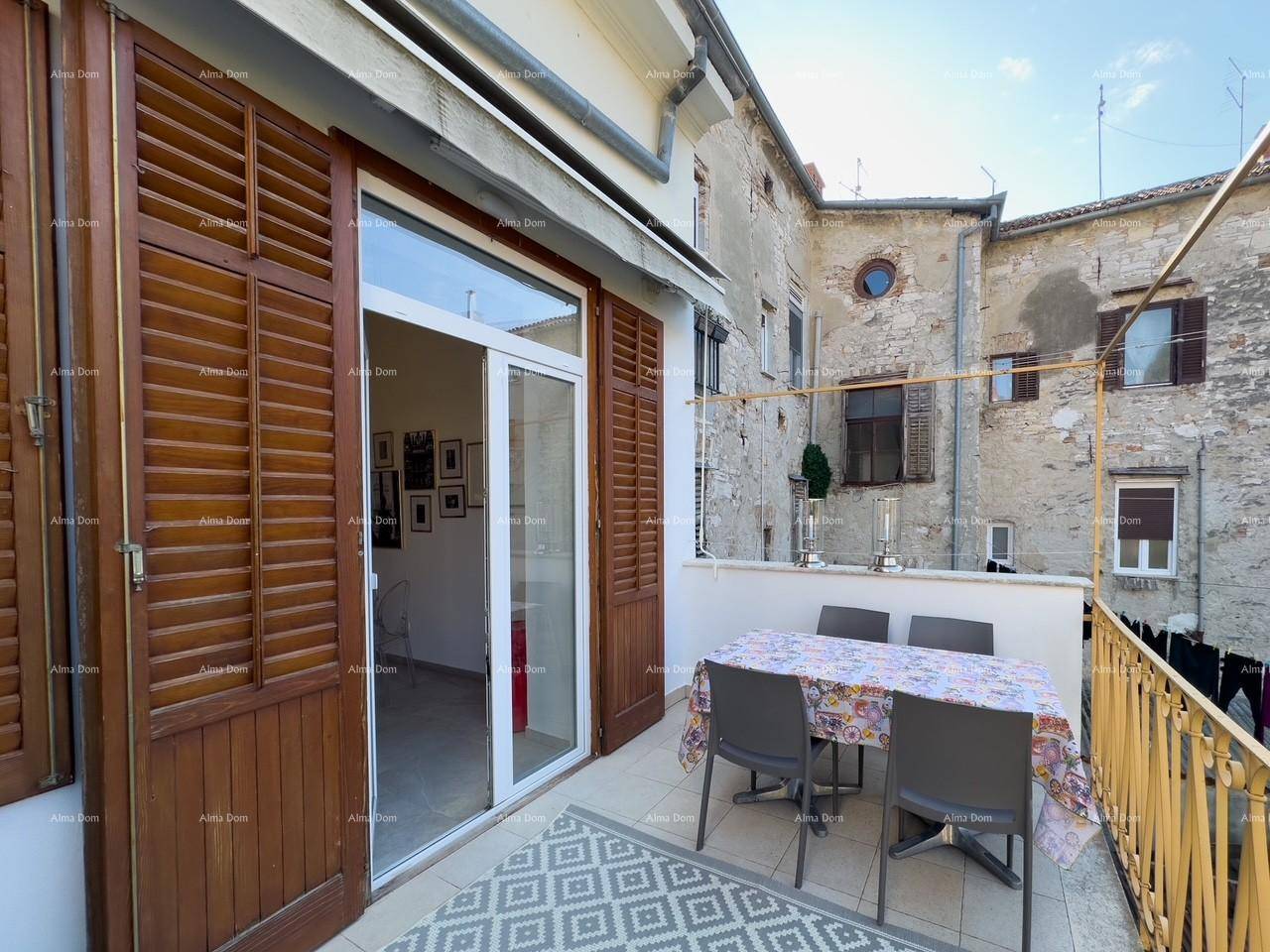 Balkon mit Essbereich und Zugang zum Innenraum, umgeben von traditioneller Architektur.