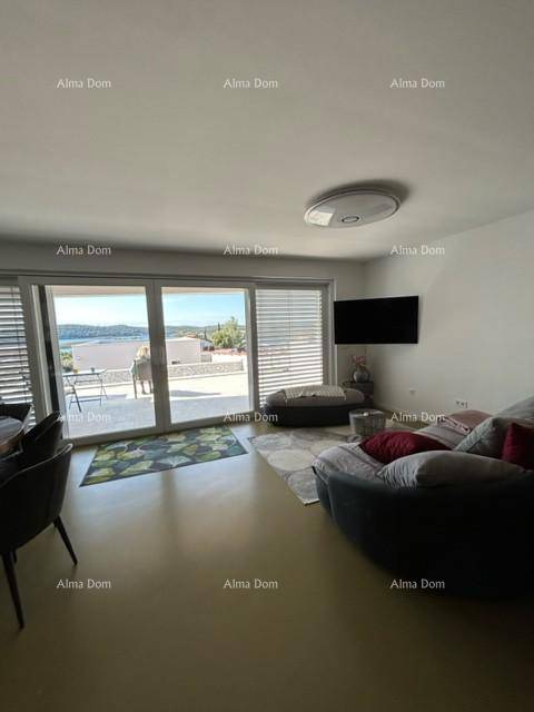 Helles Wohnzimmer mit bequemer Couch und großzügigen Schiebetüren zur Terrasse.