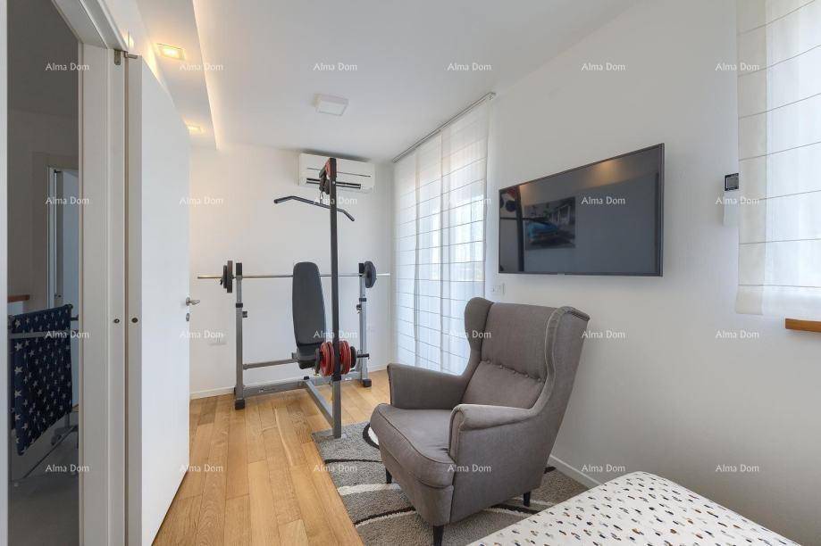 Kleiner Fitnessbereich mit Trainingsbank, Gewichten und einem Sessel, hell und modern.