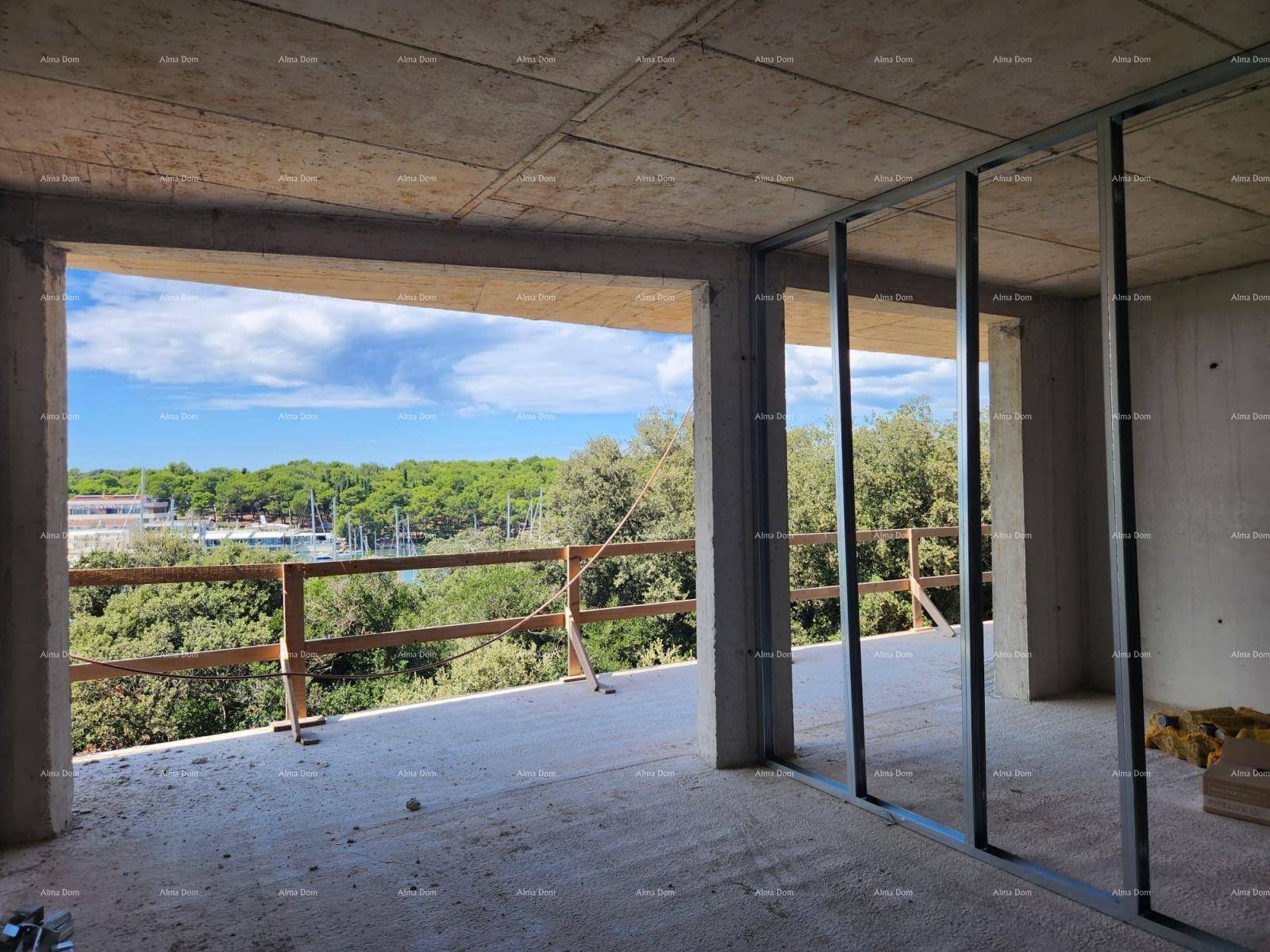 Unfertiger Innenraum mit Betonwänden und weitem Blick auf den Yachthafen und die grüne Umgebung.