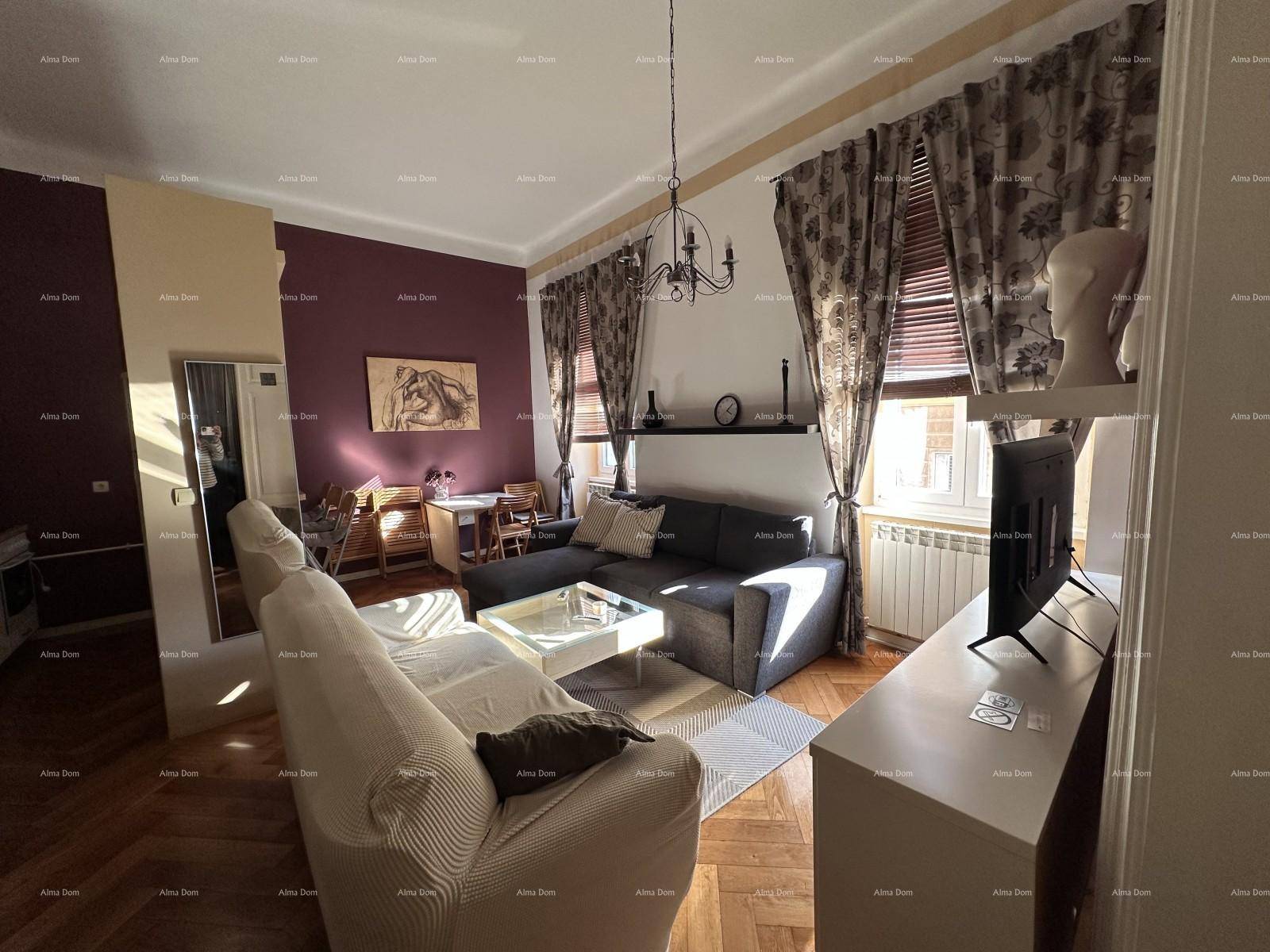 Elegantes Wohnzimmer mit Fischgrätparkett, dunklem Sofa und Kronleuchter.