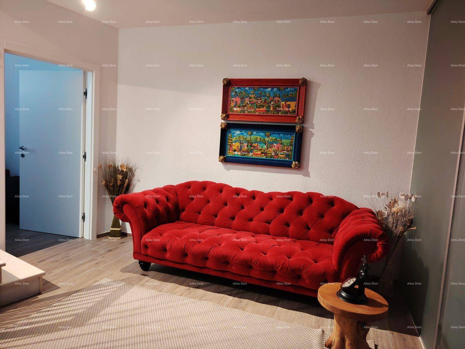 Einladender Flurbereich mit rotem Chesterfield-Sofa und hellem Holzfußboden.