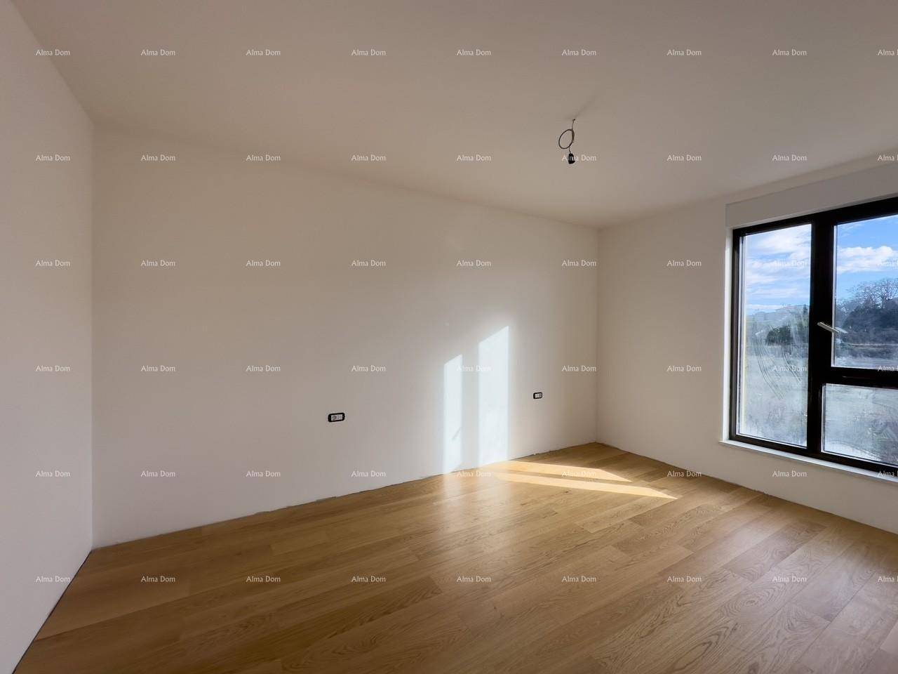 Helles Schlafzimmer im Rohbau mit Holzboden und großem Fenster.