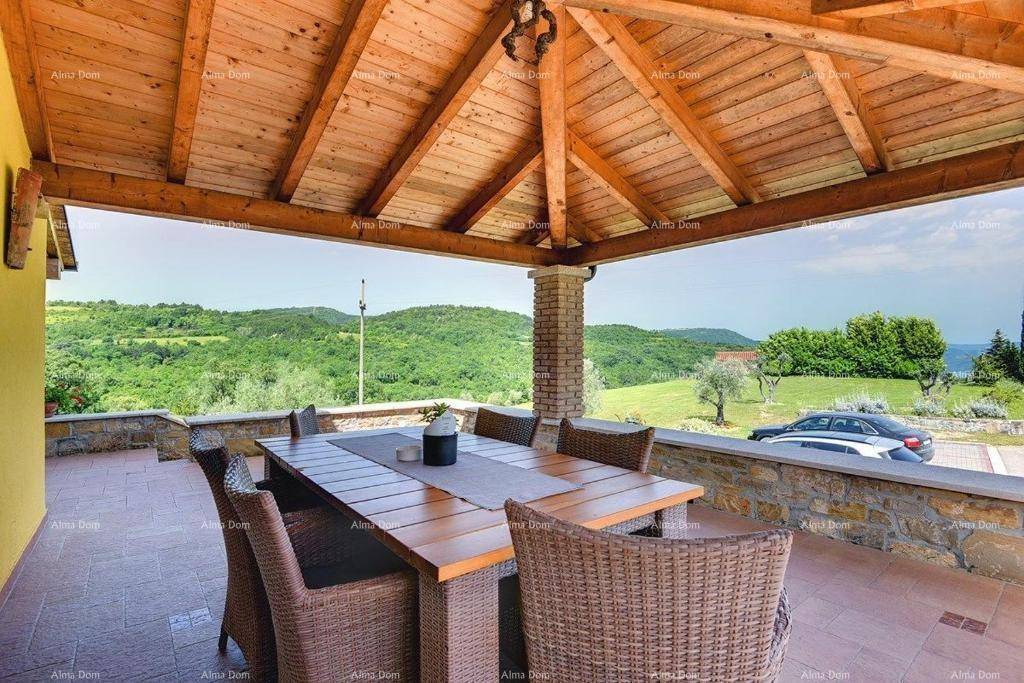 Geräumige überdachte Terrasse mit großem Esstisch und Rattanmöbeln, ideal für Mahlzeiten im Freien mit Aussicht.