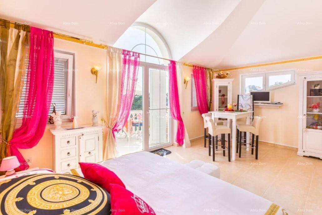 Offener Wohnbereich mit Schlafgelegenheit, Esstisch und Zugang zum Balkon.