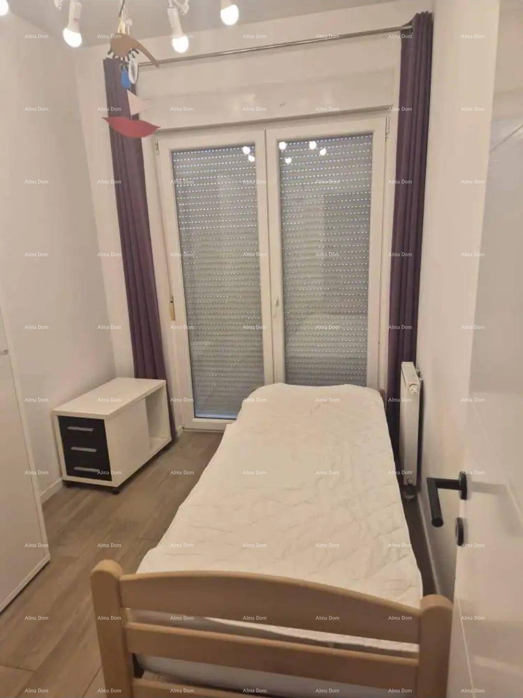 Helles Schlafzimmer mit Einzelbett, Nachttisch und Fenster mit Rollläden.