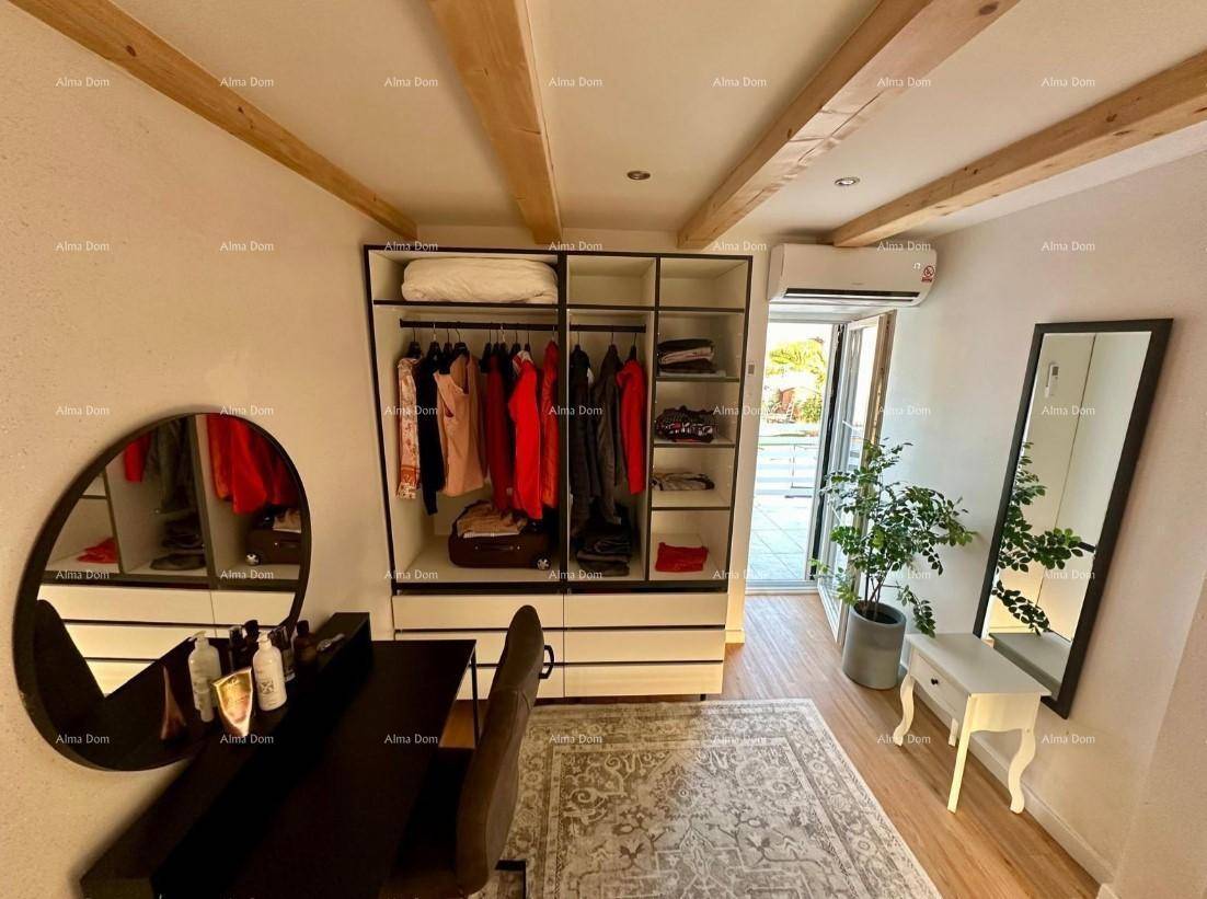 Geräumiges Schlafzimmer mit Holzbalken, offenem Kleiderschrank und Zugang zum Außenbereich.