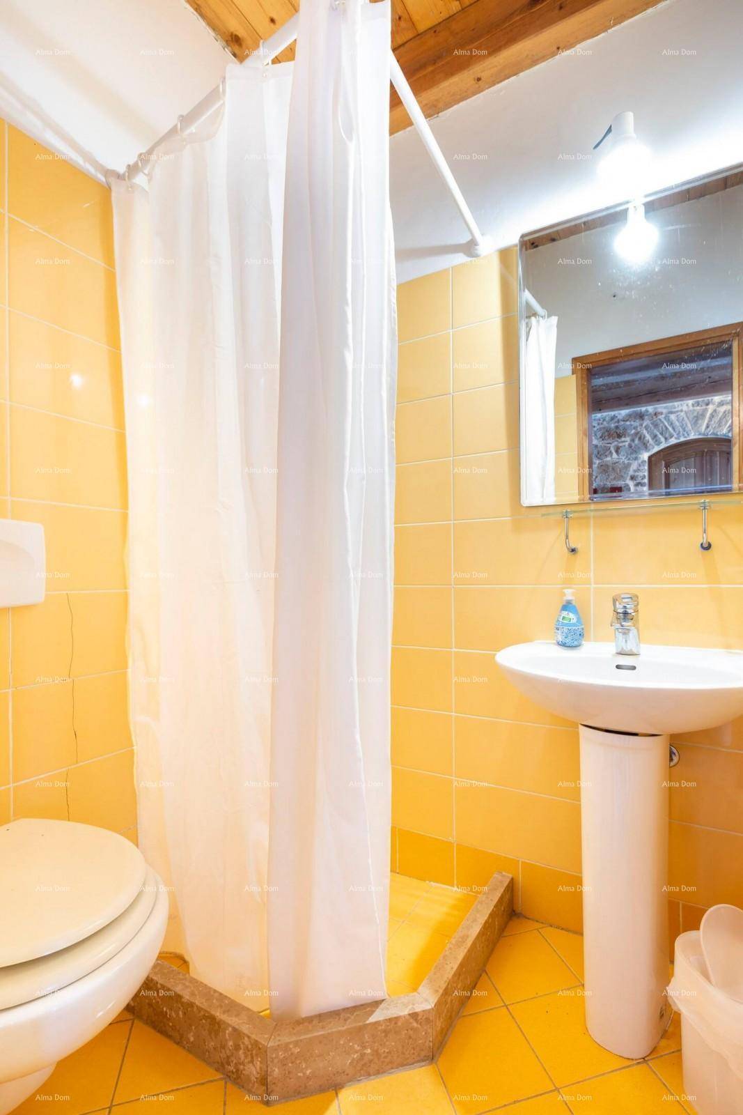 Badezimmer mit gelben Fliesen, Duschbereich und Standwaschbecken.