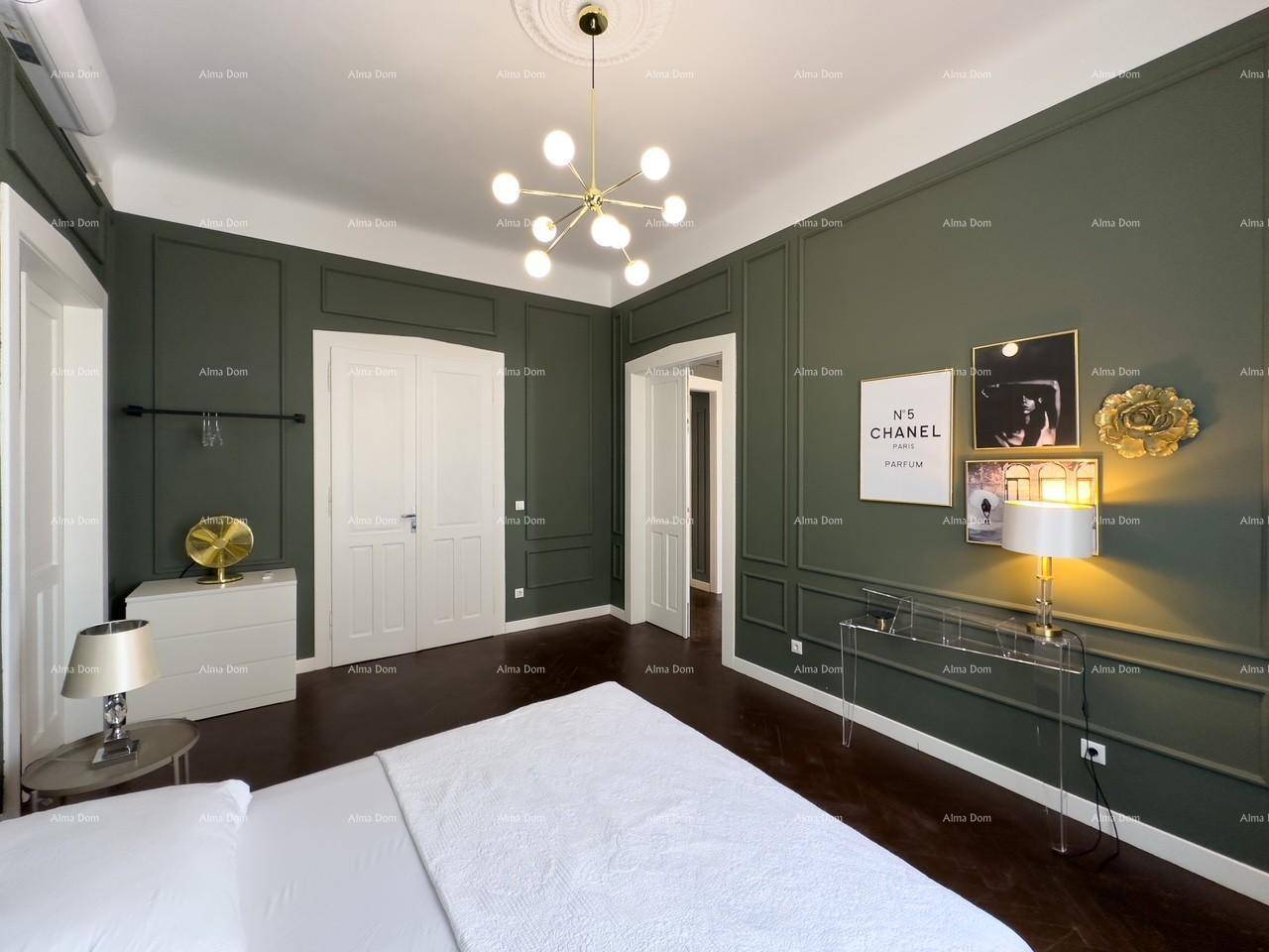 Helles Schlafzimmer mit dunklem Parkettboden, grünen Wandpaneelen und einem modernen Doppelbett.