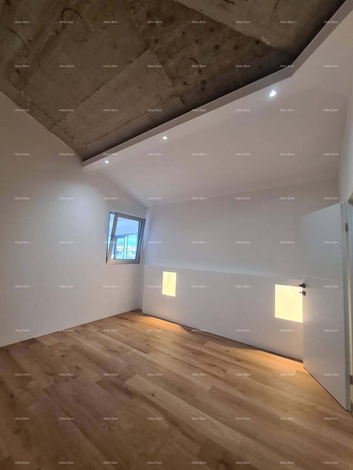 Schlafzimmer mit Holzboden, schräger Decke und einem Fenster für natürliches Licht.