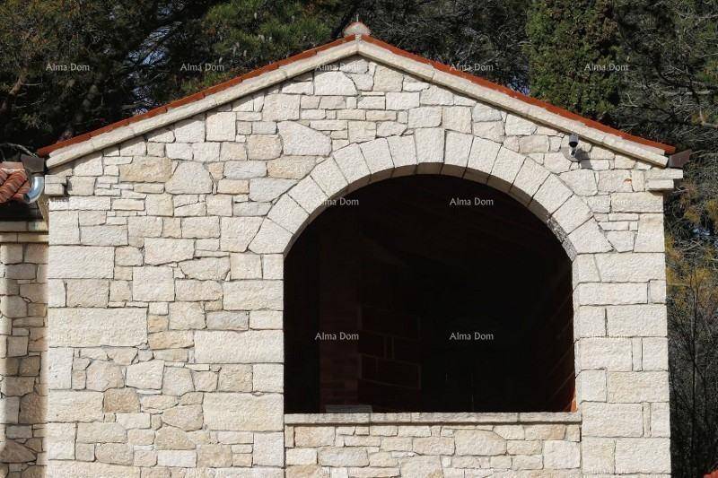 Detailaufnahme eines großen Rundbogens in der Steinfassade mit traditionellem Dach.