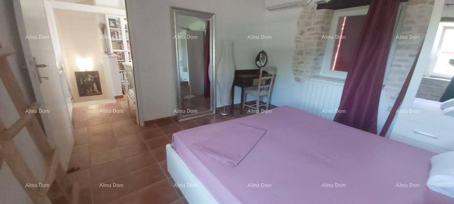 Schlafzimmer mit rosa Bettwäsche, Terrakottaboden und einem großen Spiegel.
