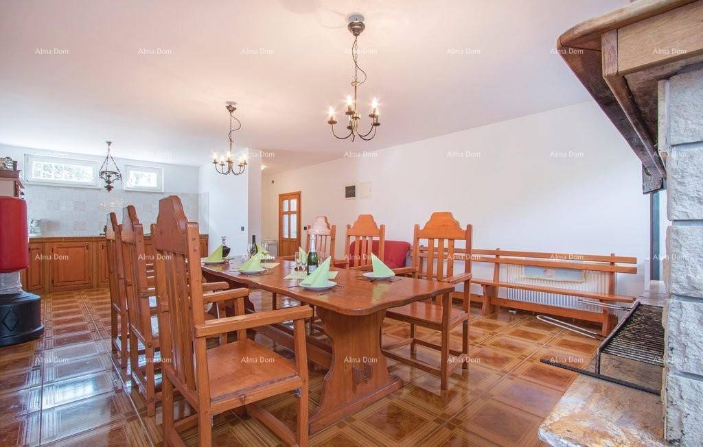 Geräumiger Essbereich mit Holztisch, Kamin und Blick in eine angrenzende Küche.