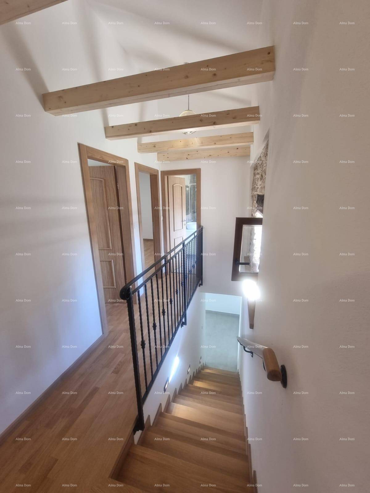 Heller Flur im Obergeschoss mit Holzboden, Holzbalken und Zugang zu mehreren Zimmern.