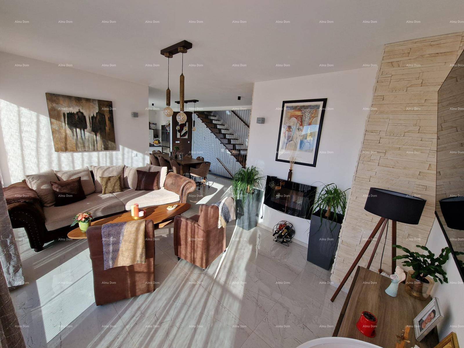 Heller Wohn- und Essbereich mit offener Gestaltung und eleganter Treppe zum Obergeschoss.
