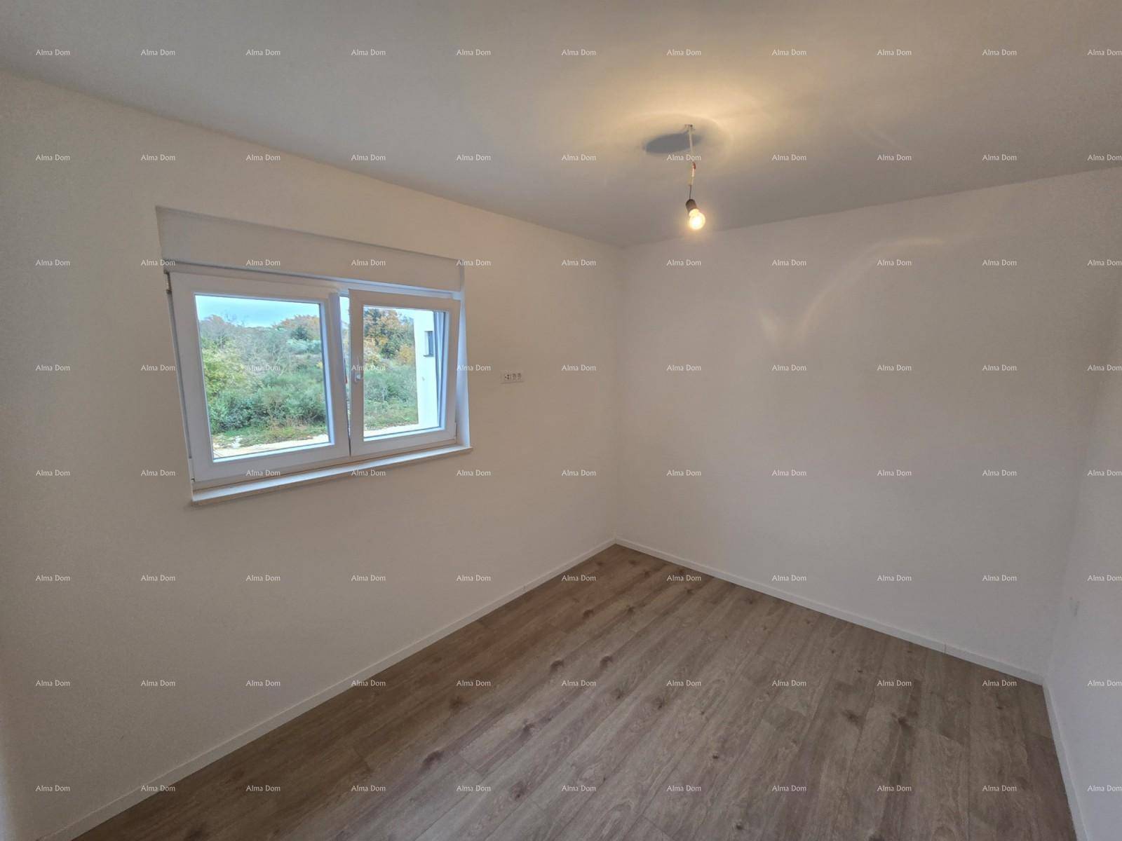 Helles Schlafzimmer mit Laminatboden und Fenster, das einen Blick ins Grüne bietet.