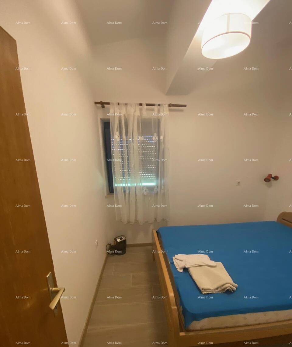 Gemütliches Schlafzimmer mit Holzbett und Fenster, das durch einen Rollladen verdunkelt werden kann.
