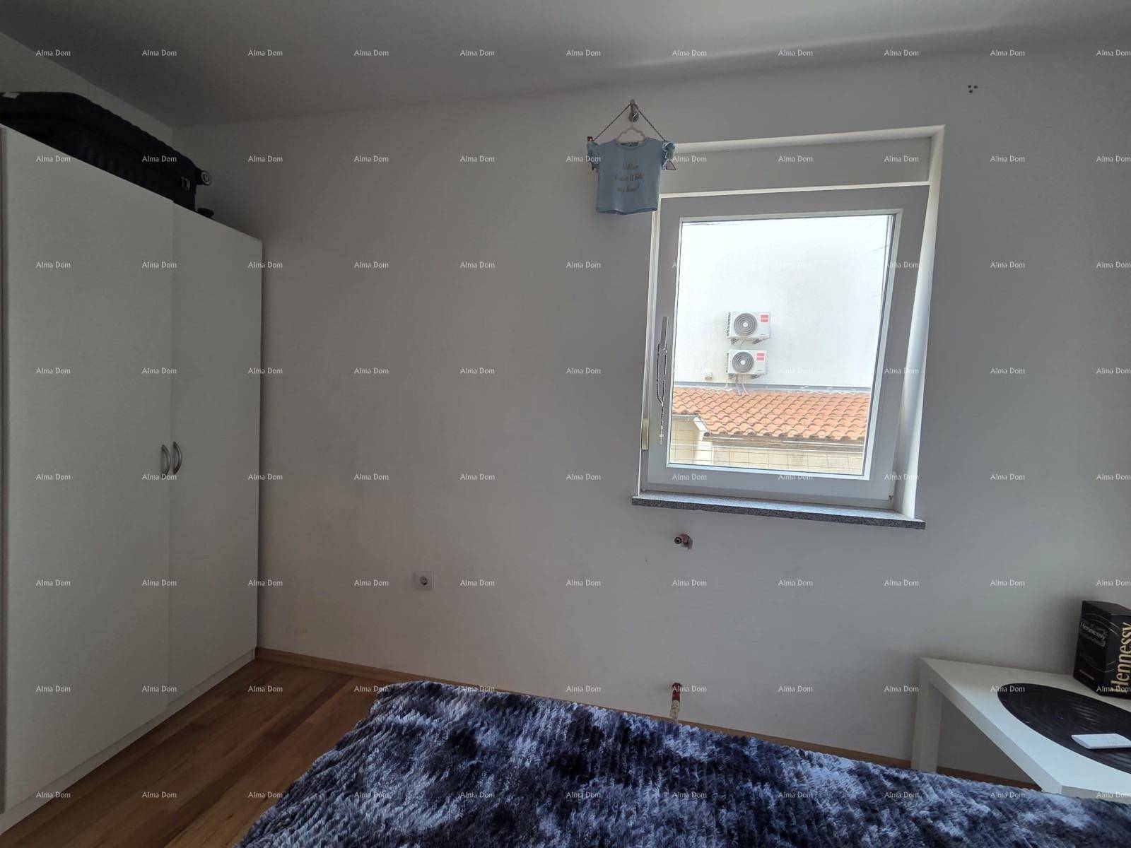 Schlafzimmer mit weißem Kleiderschrank und Fenster, das einen Blick auf die Umgebung bietet.