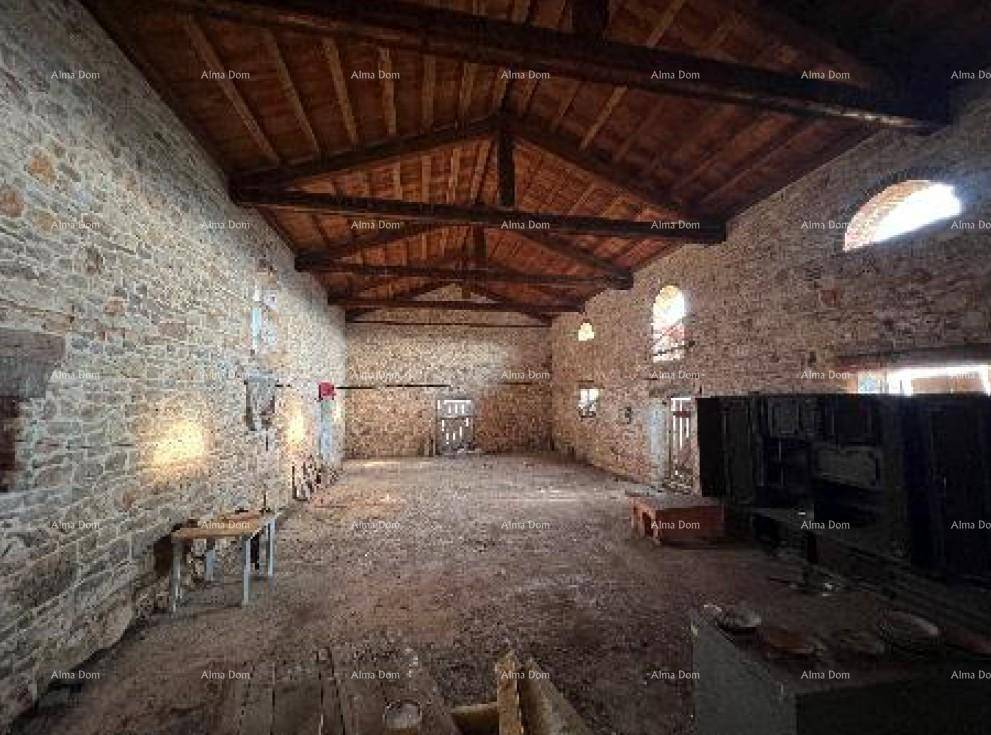 Großer, unfertiger Innenraum mit freiliegenden Steinwänden und Holzbalkendecke, bereit zur Renovierung.