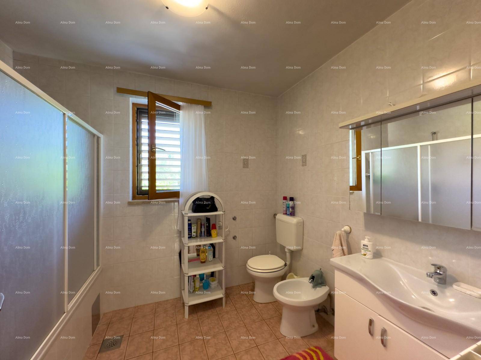 Badezimmer mit Dusche, WC, Bidet, Waschbecken und Spiegelschrank.