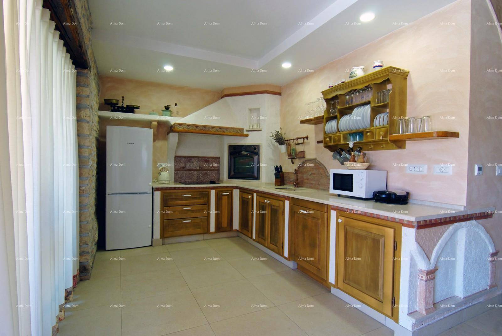 Traditionelle Küche mit hellen Holzschränken, integriertem Backofen und viel Arbeitsfläche.