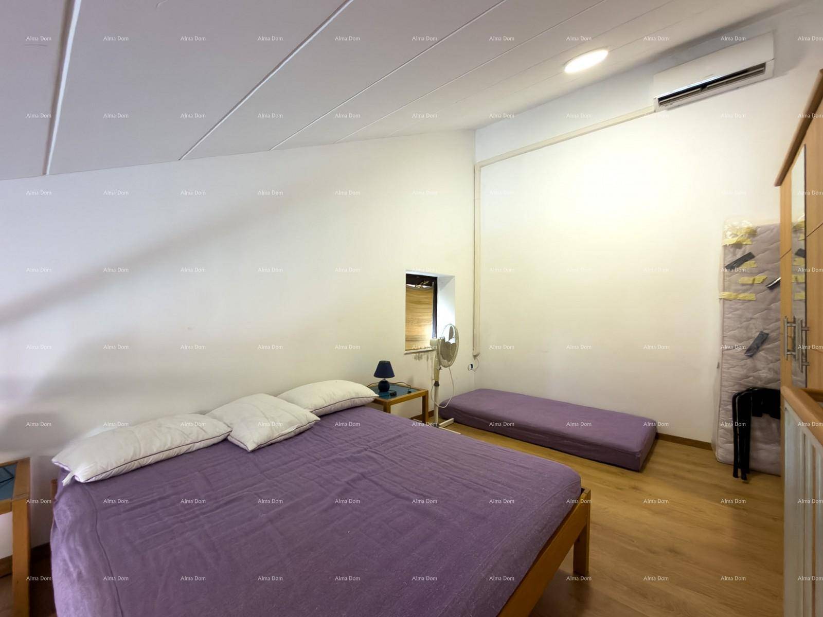 Schlafzimmer auf einer Galerieebene mit Doppelbett und Kleiderschrank.