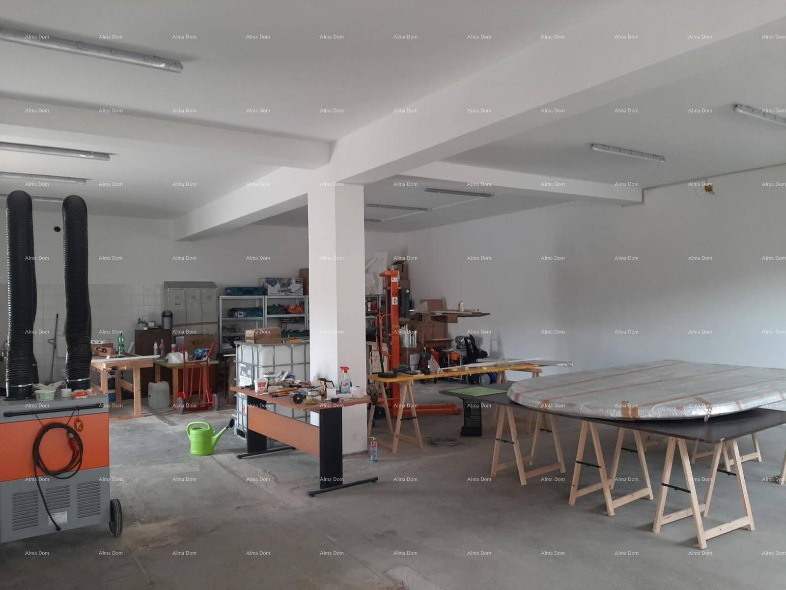 Großer Werkstattraum mit Betonboden und verschiedenen Arbeitsbereichen.