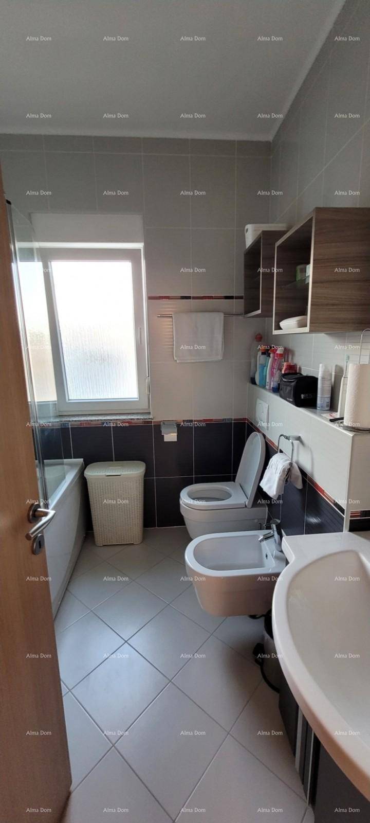 Badezimmer mit Toilette, Bidet, Waschbecken und einem Fenster für natürliche Belüftung.