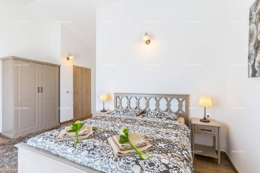 Schlafzimmer mit Doppelbett, gemustertem Bettzeug und Holzboden, der eine gemütliche Atmosphäre schafft.