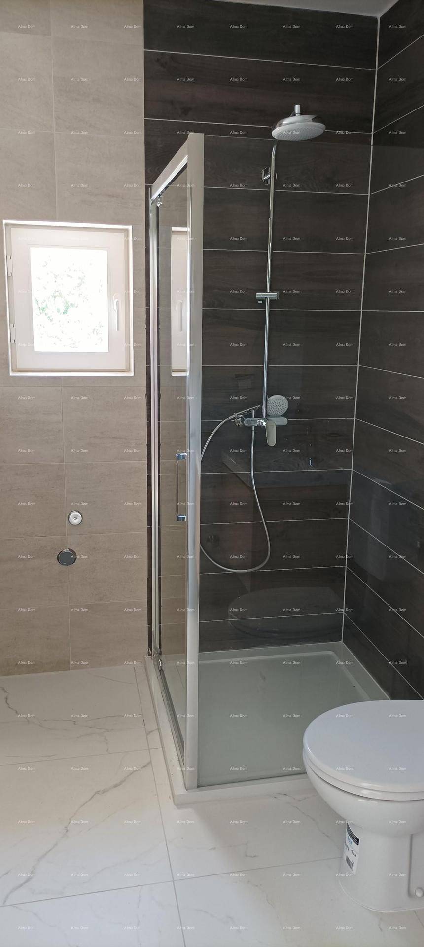 Modernes Badezimmer mit Duschkabine, Wand-WC und großformatigen Fliesen an Wänden und Boden.