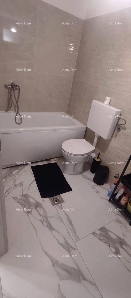 Modernes Badezimmer mit Badewanne, Toilette und hellen Fliesen an Wänden und Boden.