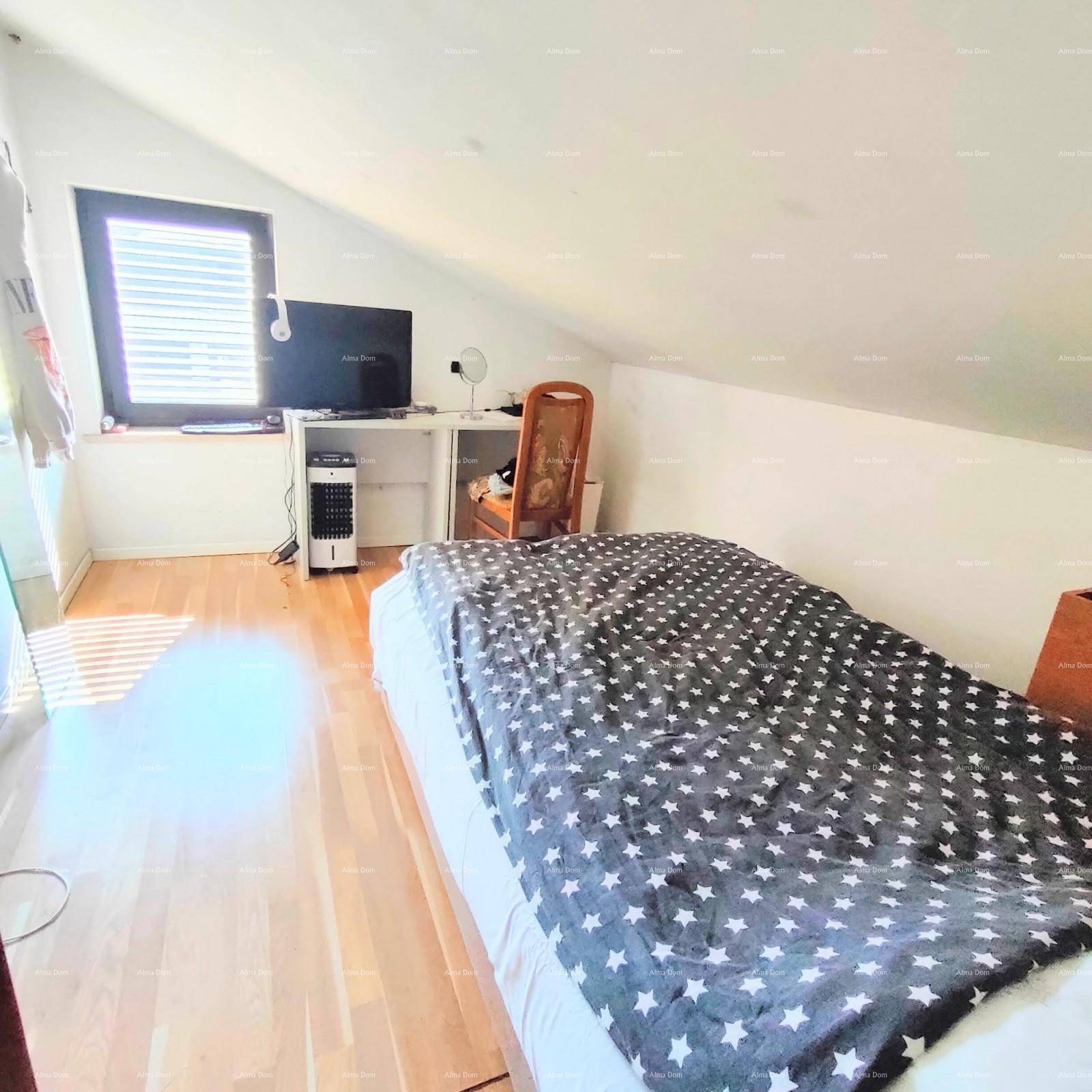 Helles Dachschlafzimmer mit Holzboden, Fenster und einem Bett mit Sternenmuster-Bettwäsche.